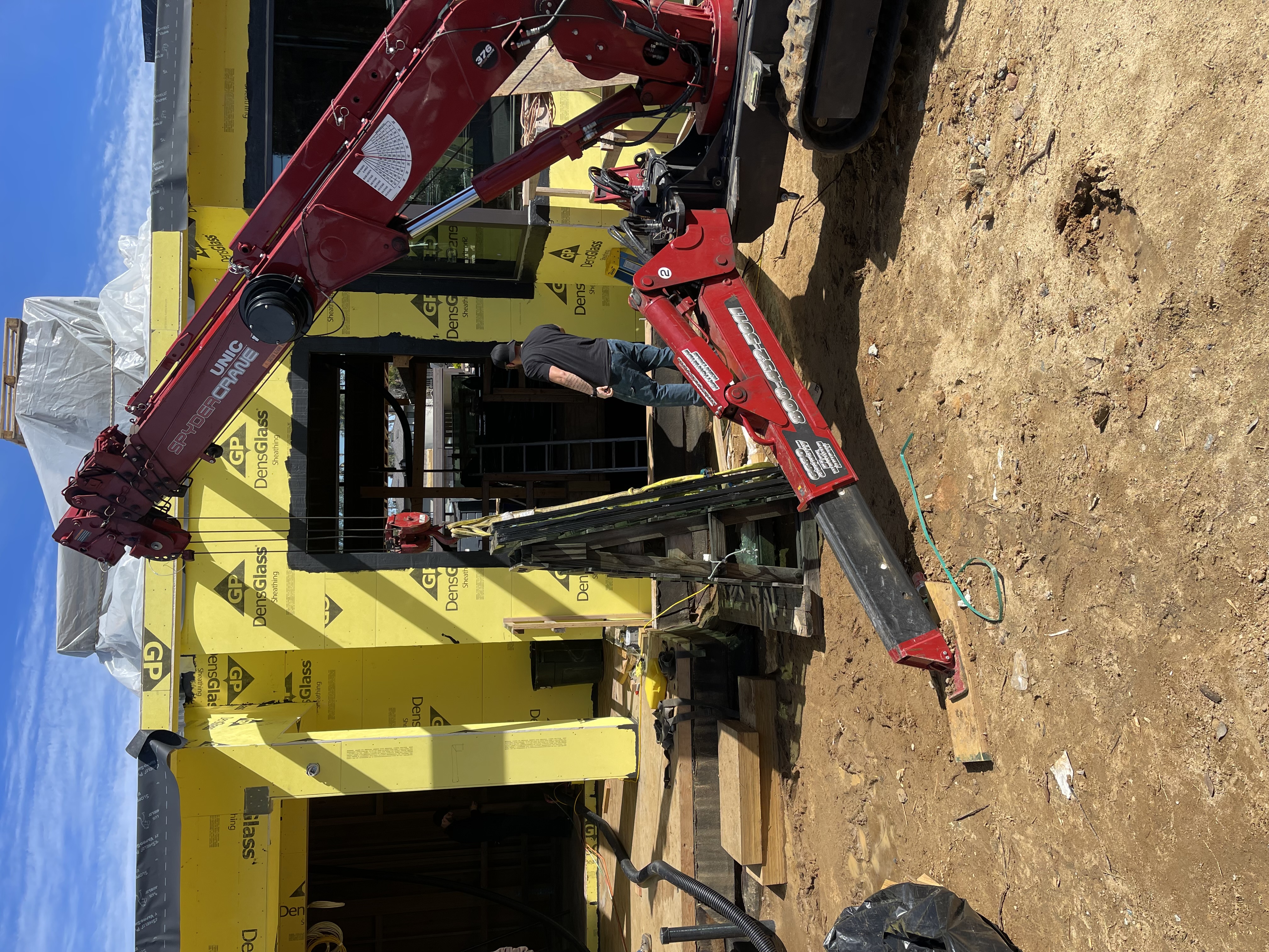 SPYDERCRANE mini crane lifting glass at a building